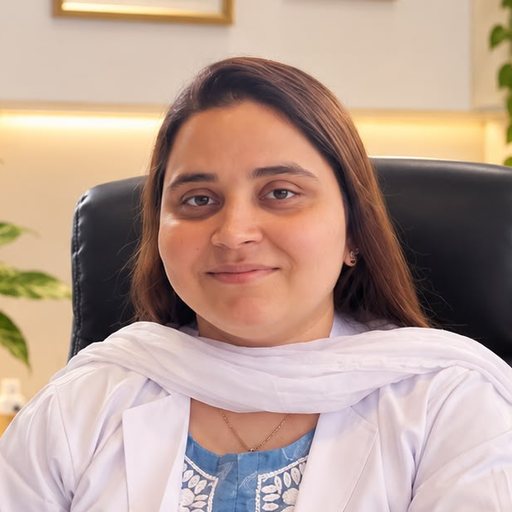 Dr Lubna Shaikh in a white coat at her desk at Absolute Cosmetic Clinic