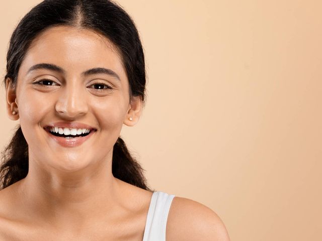 A smiling woman with bright, healthy-looking skin