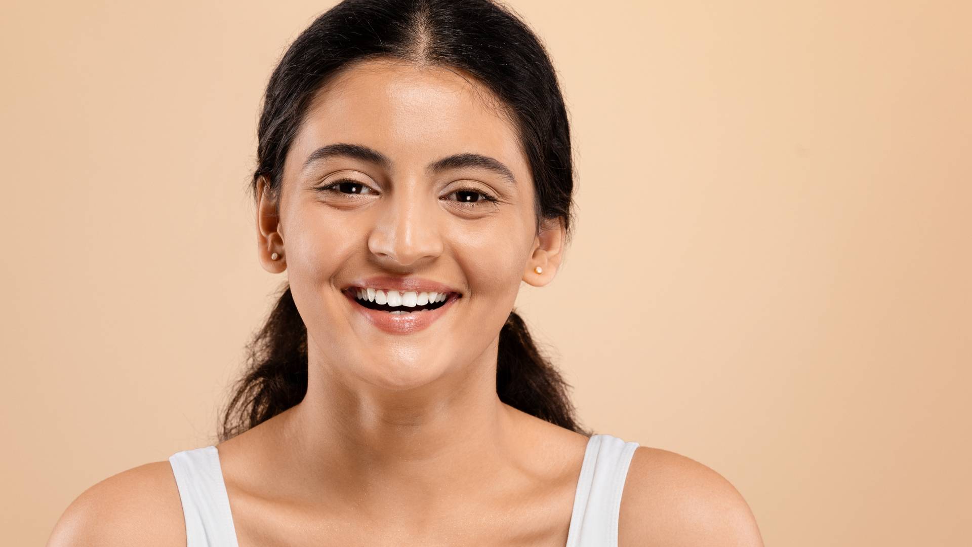 A smiling woman with bright, healthy-looking skin