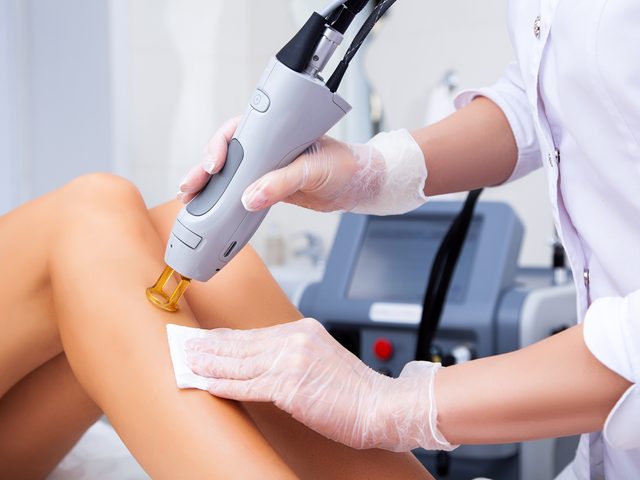 A clinician performing laser hair removal on a patient&rsquo;s leg